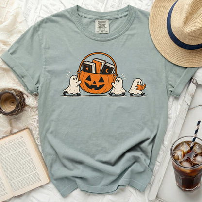 Three ghosts carry a jack-o'-lantern basket filled with books, with one ghost reading.
