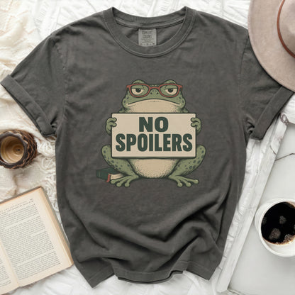 T-shirt with graphic of frog wearing glasses holding a "NO SPOILERS" sign.