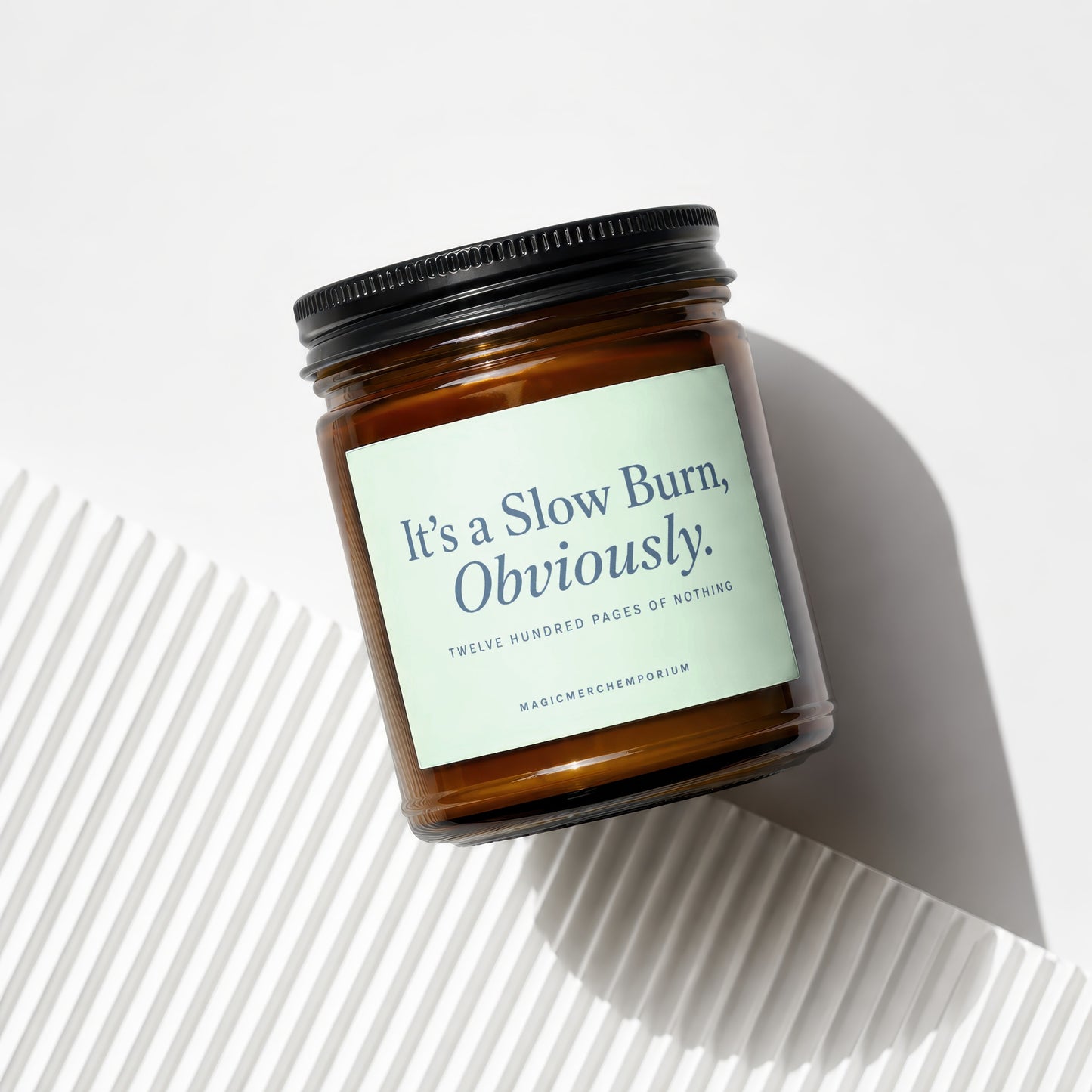 Candle with black lid, inscribed "It's a Slow Burn, Obviously."