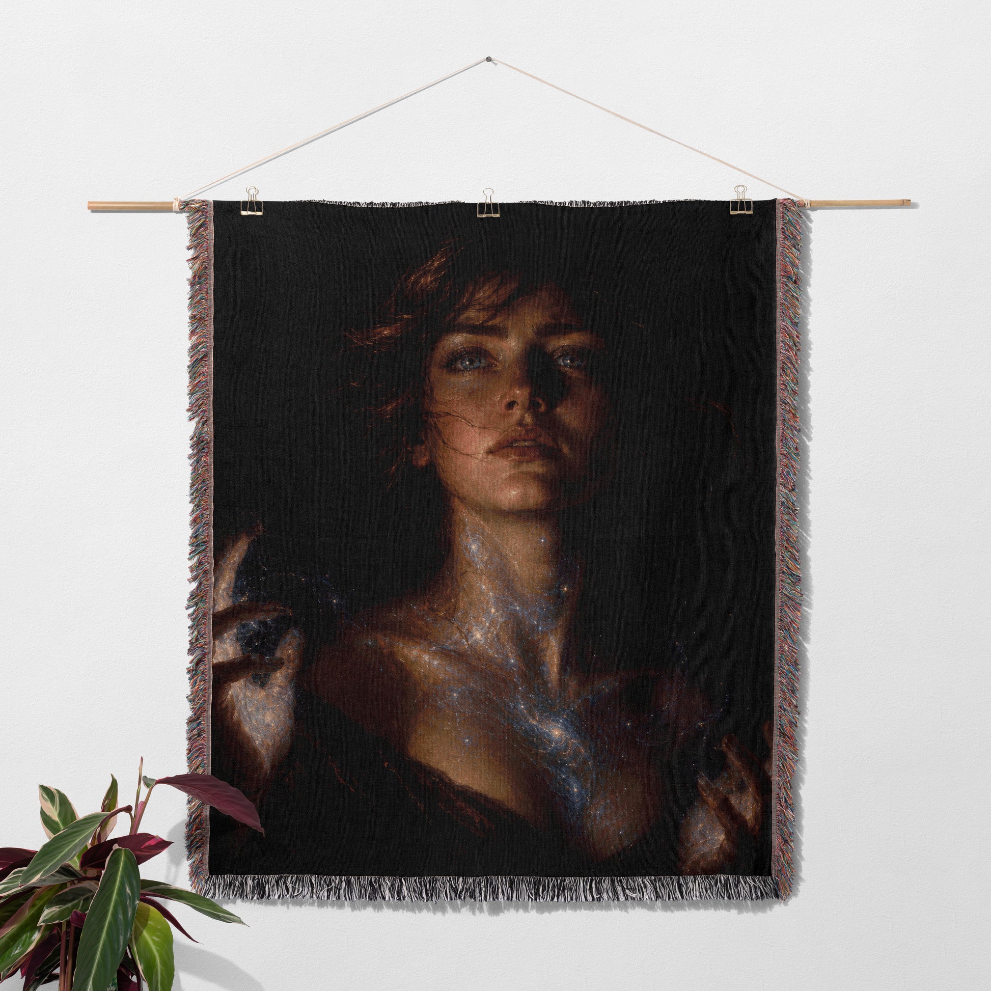 a large portrait of a woman hanging on a wall, with a potted plant to the left of the frame.