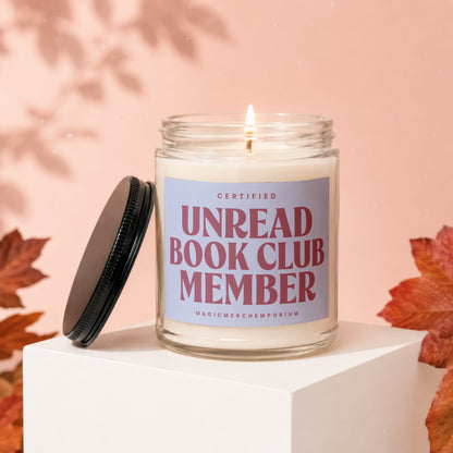 Candle with "Certified Unread Book Club Member" label and lit wick.