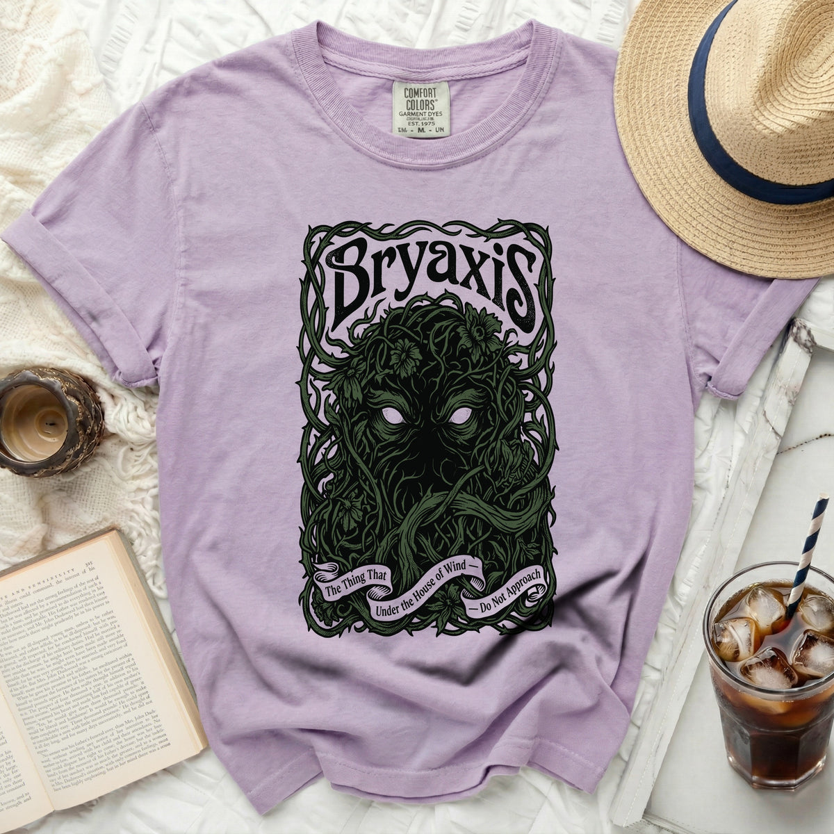 Lilac t-shirt with "Bryaxis The Thing That Under the House of Wind - Do Not Approach" graphic.