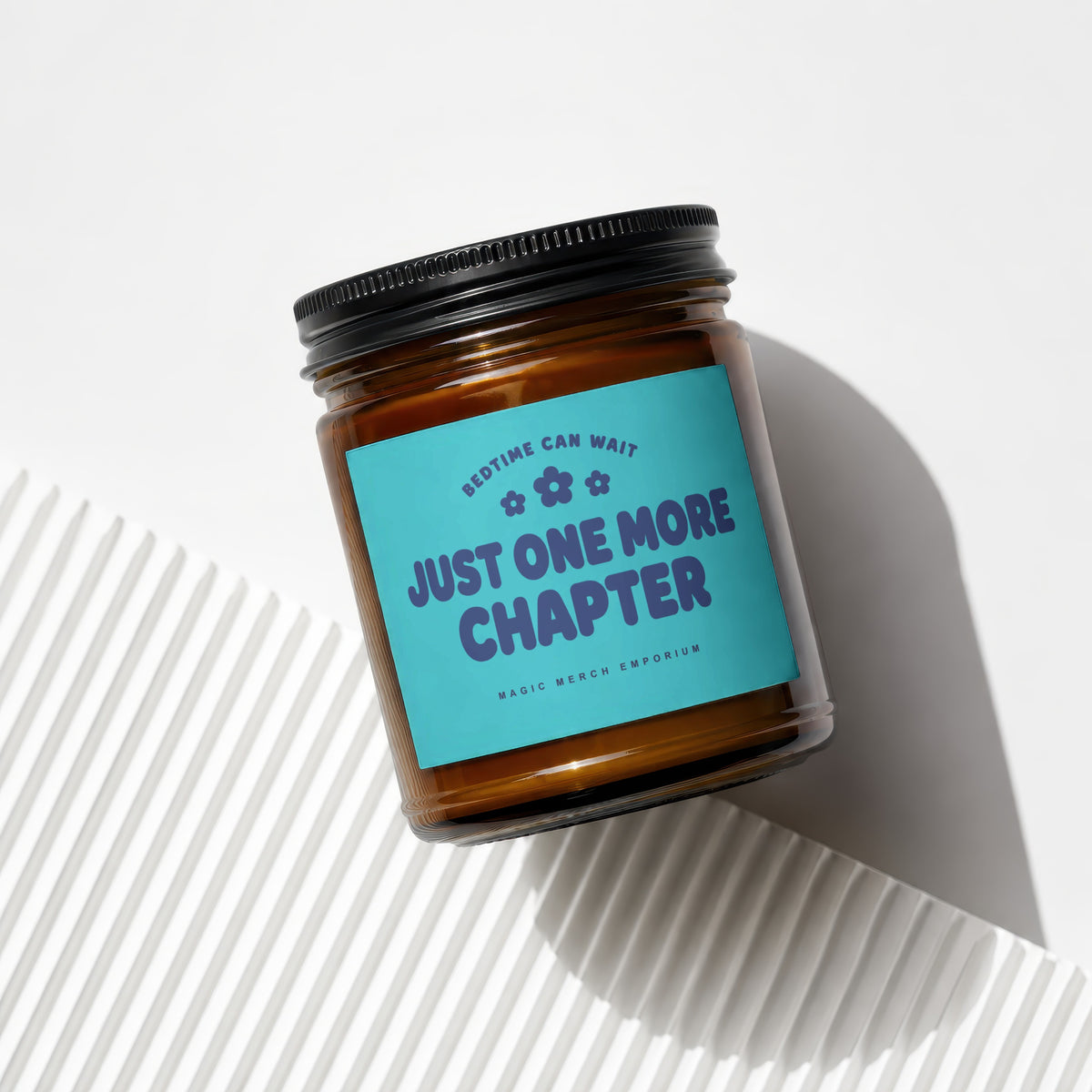 Candle with blue label reading "Bedtime Can Wait, Just One More Chapter".