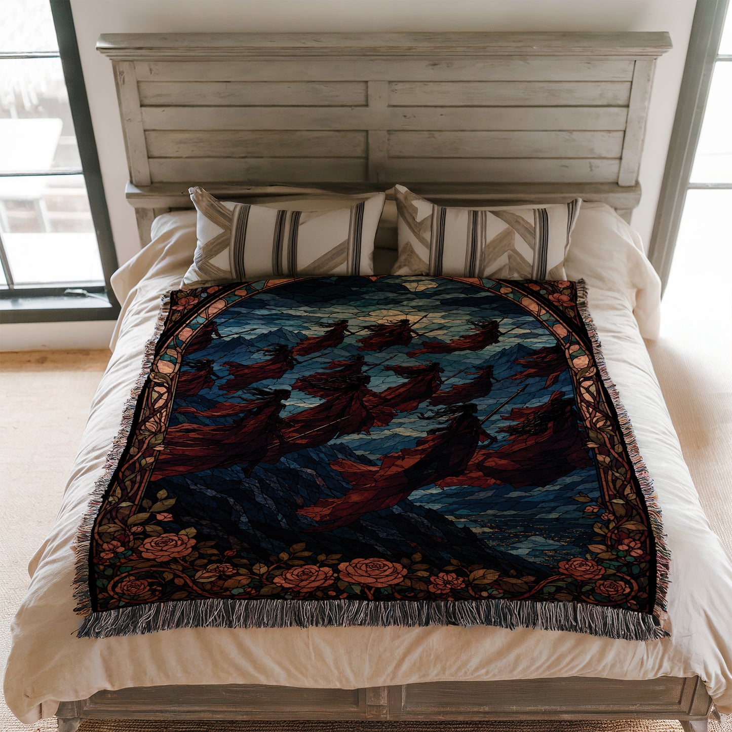 a bed with a colorful, patterned blanket and pillows. The blanket features a design of flying figures against a night sky background.