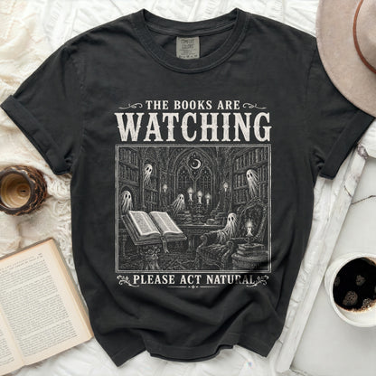 T-shirt with "The Books Are Watching. Please Act Natural" text and gothic illustration.