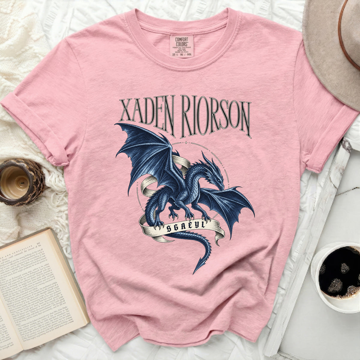 Pink t-shirt with a blue dragon graphic and text "XADEN RIORSON SGAEYL".