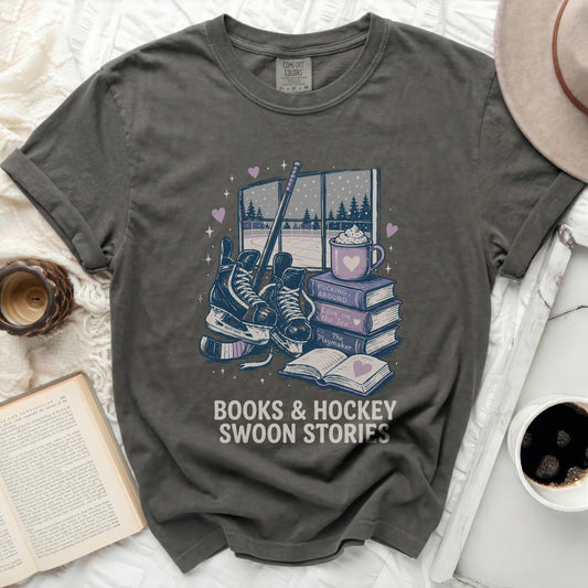 Dark grey t-shirt with books, skates, and hot cocoa graphic and text.