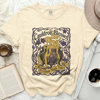 Cream t-shirt with "Cauldron Blessed Prythian Magic Tour" graphic.