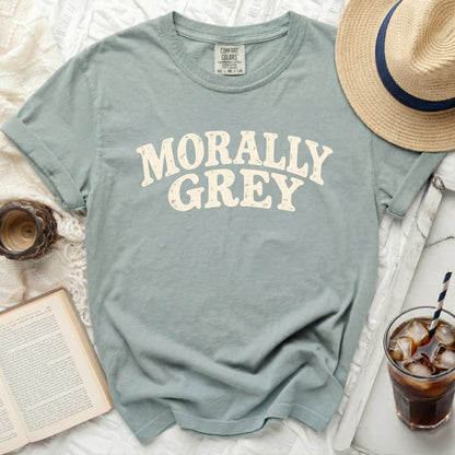Sage green t-shirt with "MORALLY GREY" text, Comfort Colors tag, straw, and hat.