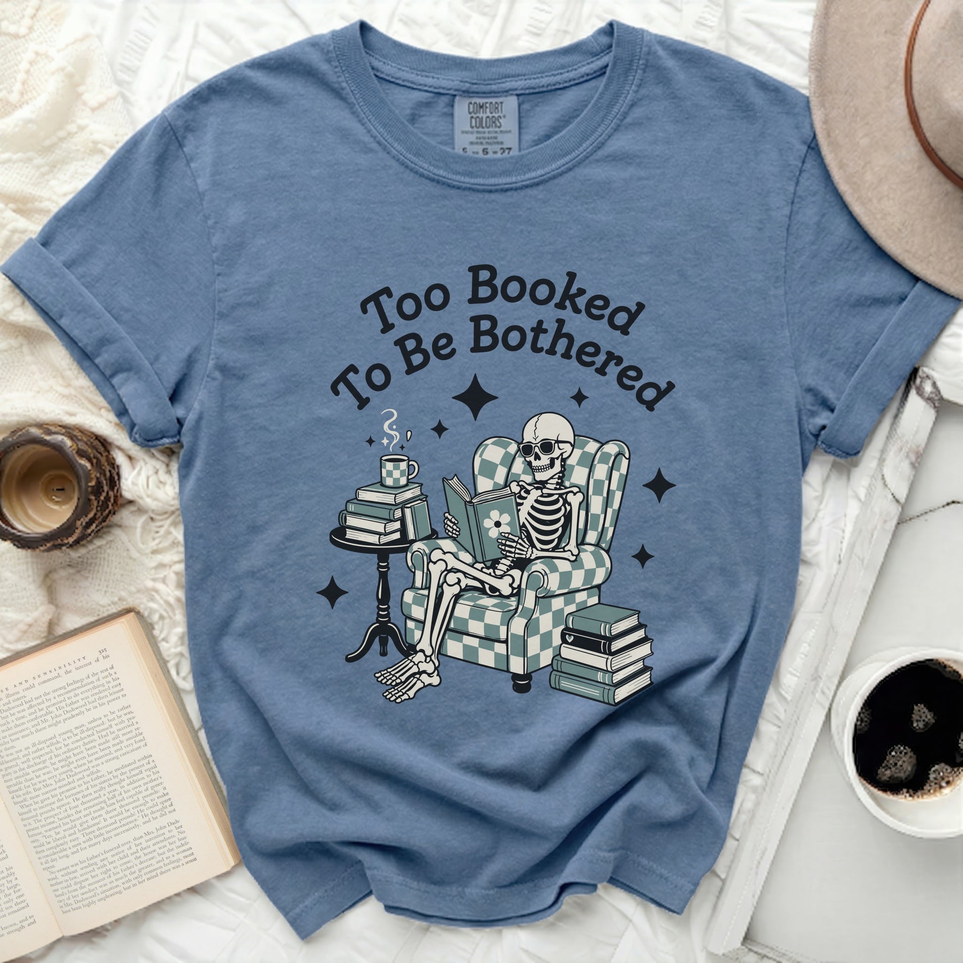 T-shirt with skeleton reading book and text "Too Booked To Be Bothered".