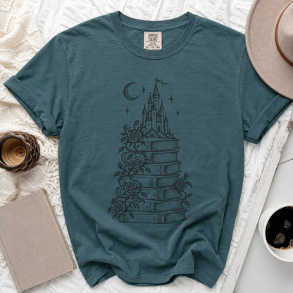 Teal crewneck t-shirt featuring a dark graphic of a castle atop a stack of books with climbing roses.