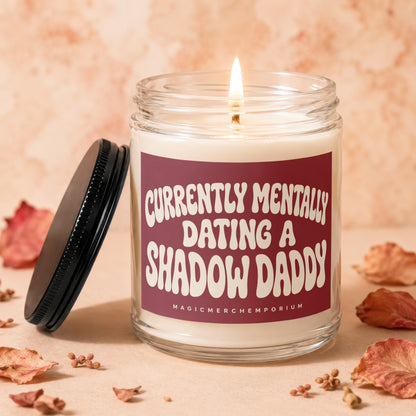 Candle with text "Currently Mentally Dating A Shadow Daddy" on maroon label.
