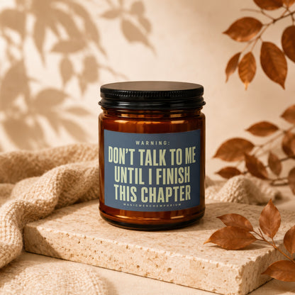 Amber candle with a black lid, reading "Don't talk to me until I finish this chapter".