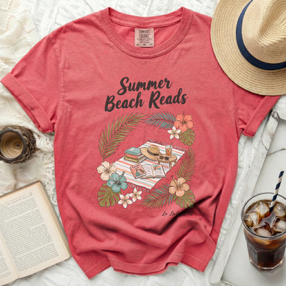 Coral t-shirt with "Summer Beach Reads" graphic featuring books, hat, and tropical foliage.