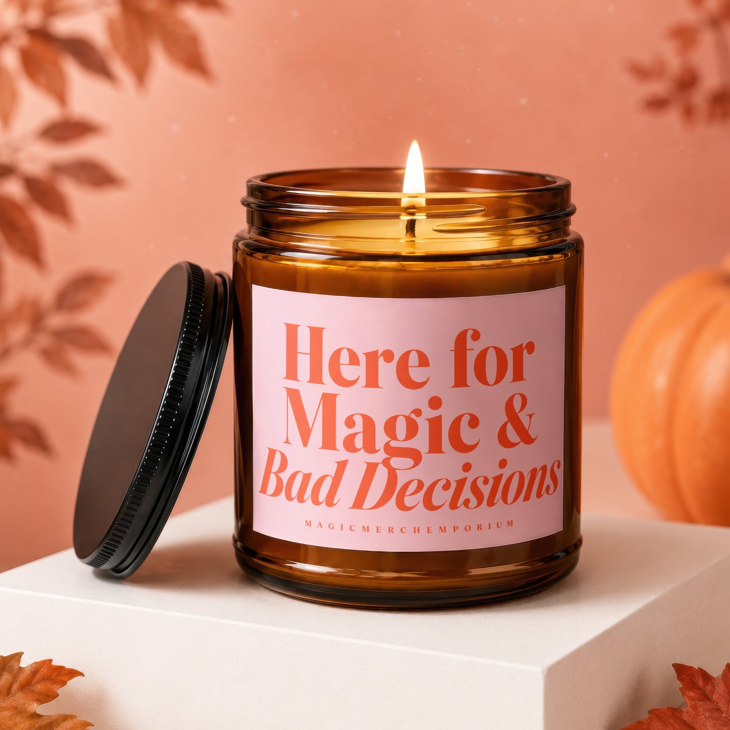 Amber jar candle with pink label reading "Here for Magic & Bad Decisions".