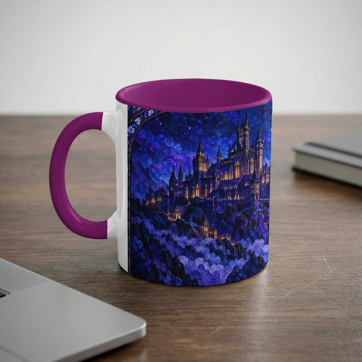 A white ceramic mug with a purple handle and rim, featuring a blue stained-glass style castle print on a desk.