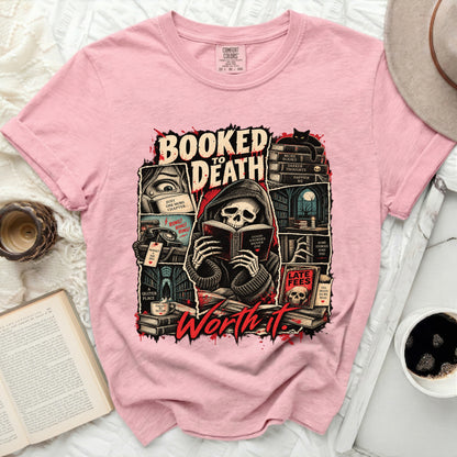 Pink t-shirt graphic with grim reaper reading, "Booked to Death," and other book-themed text.