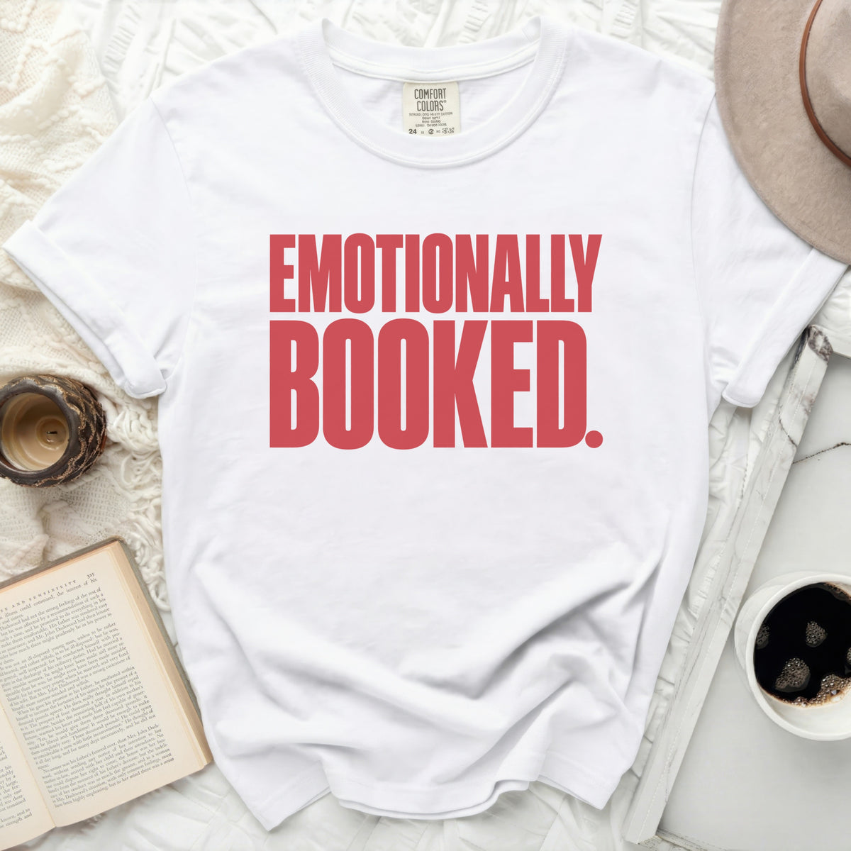 White t-shirt with red text "Emotionally Booked."