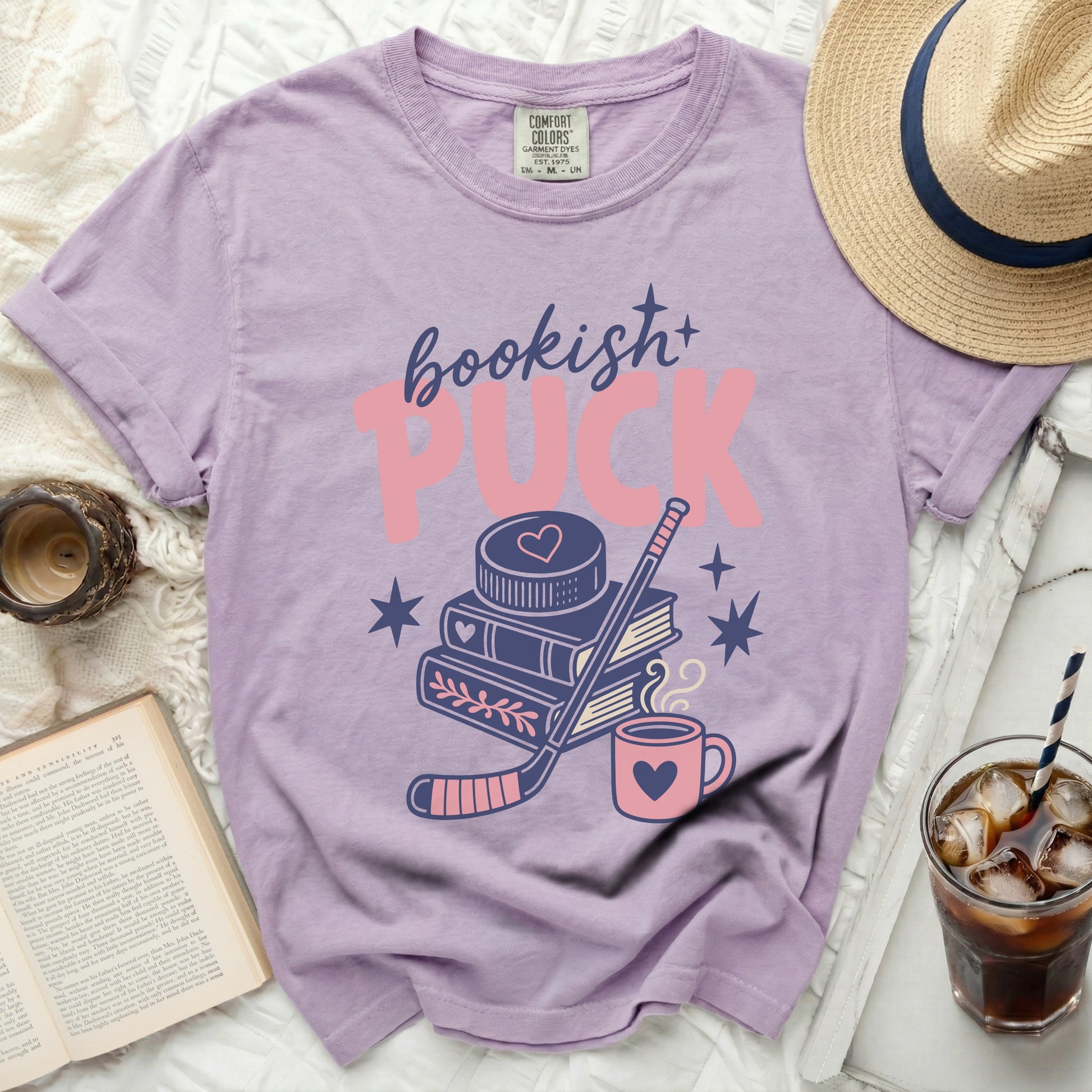 Purple t-shirt with "bookish+ Puck" graphic featuring books and hockey stick.