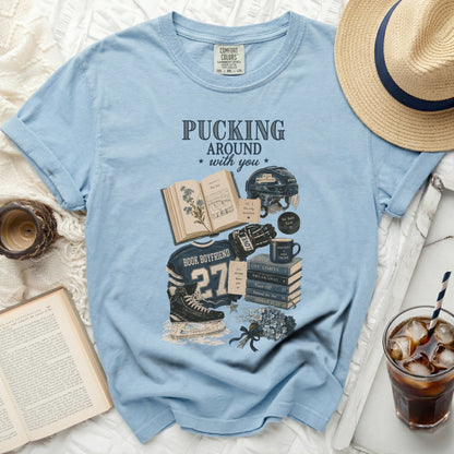 Light blue t-shirt with "Pucking Around with You" book and hockey graphics.