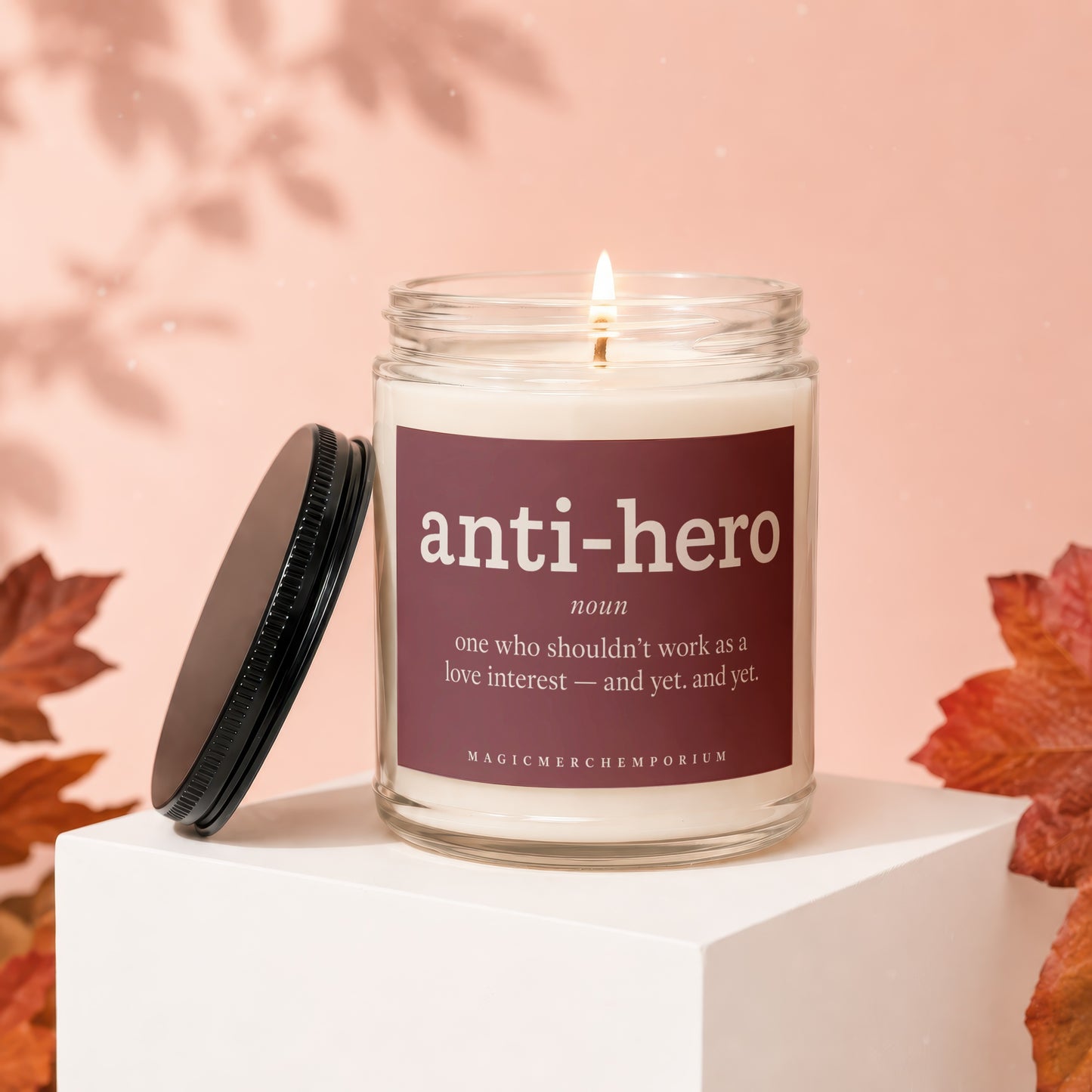 Glass candle with "anti-hero" definition on label and black lid.