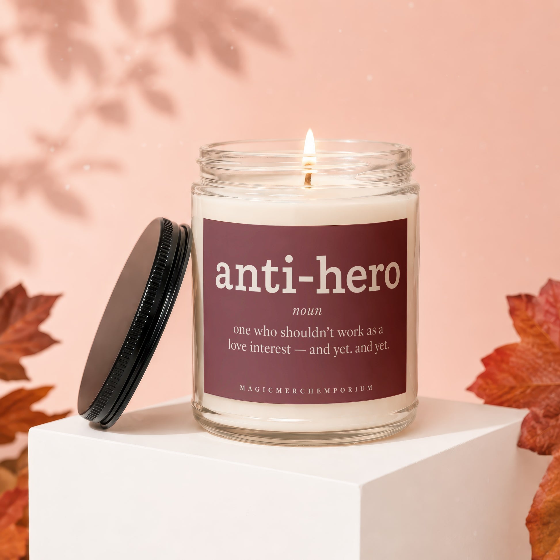 Glass candle with "anti-hero" definition on label and black lid.