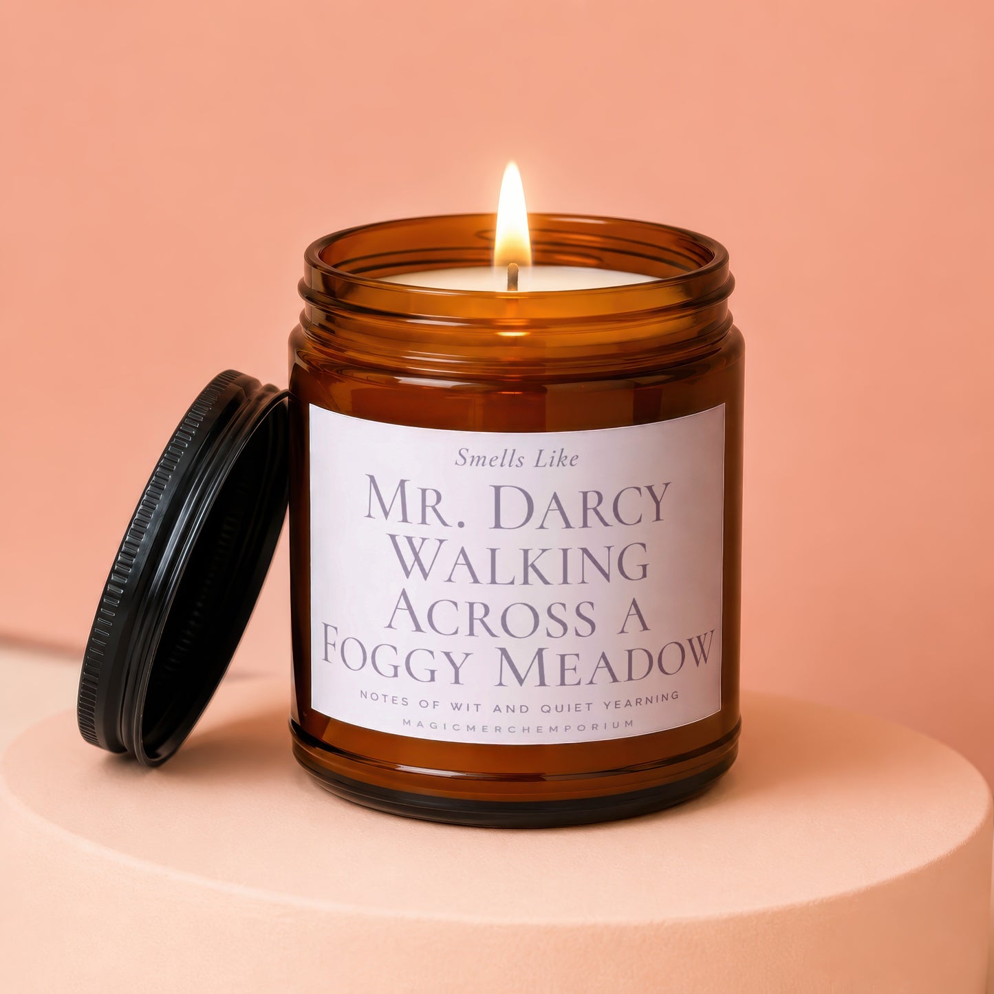 Amber jar candle labeled "Mr. Darcy Walking Across a Foggy Meadow" with lit wick.