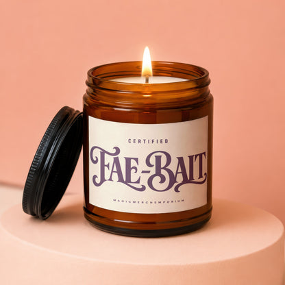 Amber jar candle with lid off, reads "CERTIFIED Fae-Bait MAGICMERCH..."