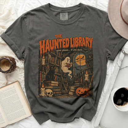 The Haunted Library graphic tee features books, a black cat, ghost, pumpkin, and moon.