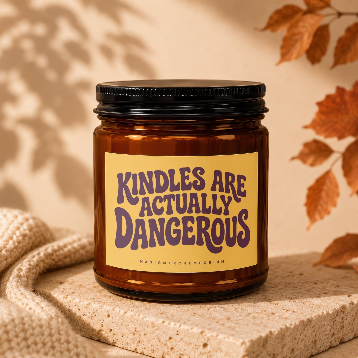 Brown glass candle with yellow label reading "KINDLES ARE ACTUALLY DANGEROUS".