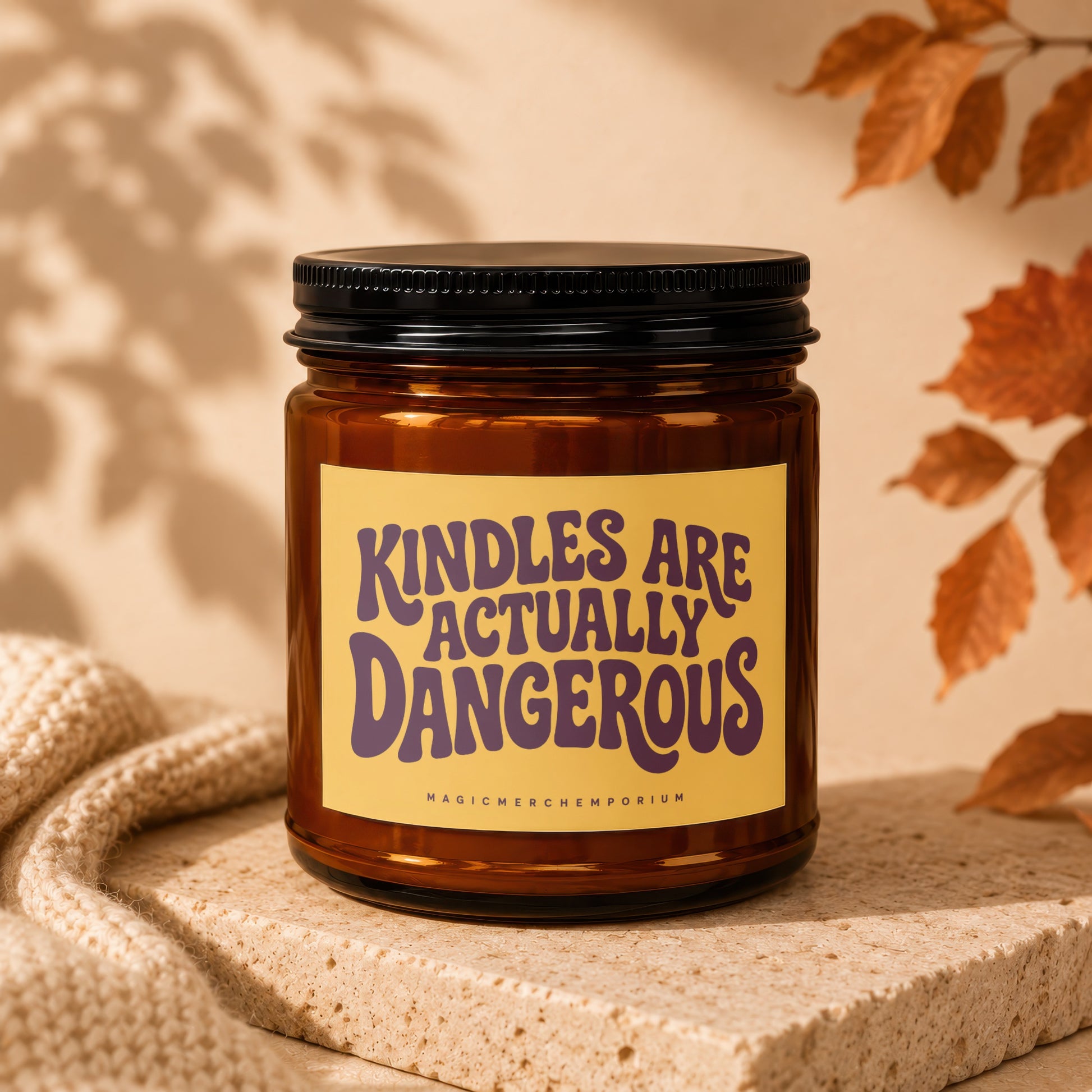 Brown glass candle with yellow label reading "KINDLES ARE ACTUALLY DANGEROUS".