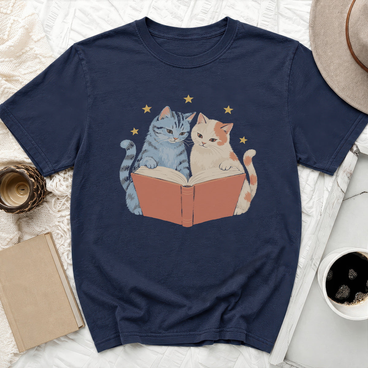 Navy t-shirt with two cartoon cats reading an open book and stars.
