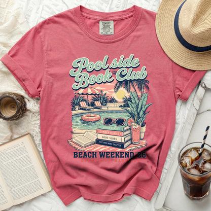 Pink t-shirt with "Poolside Book Club" graphic and book motifs.