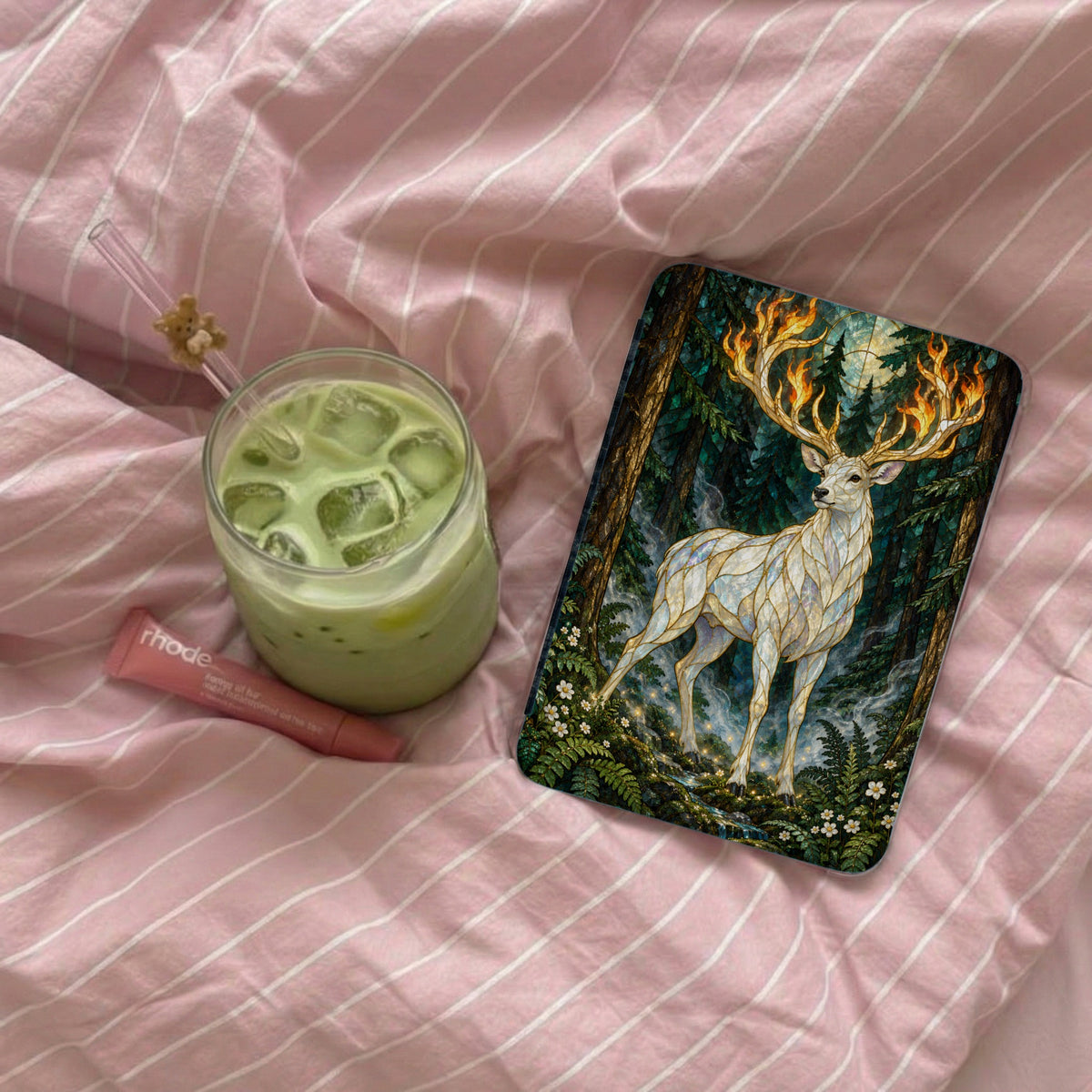 White deer with flaming antlers in a forest scene on a phone case.