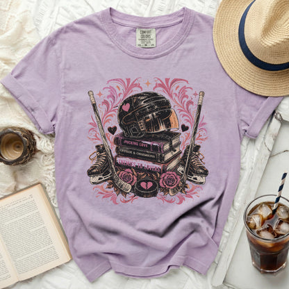 Lavender t-shirt with hockey helmet, skates, and book titles: Pucking Love, Offside & Obsessions, Enemies to Lovers.