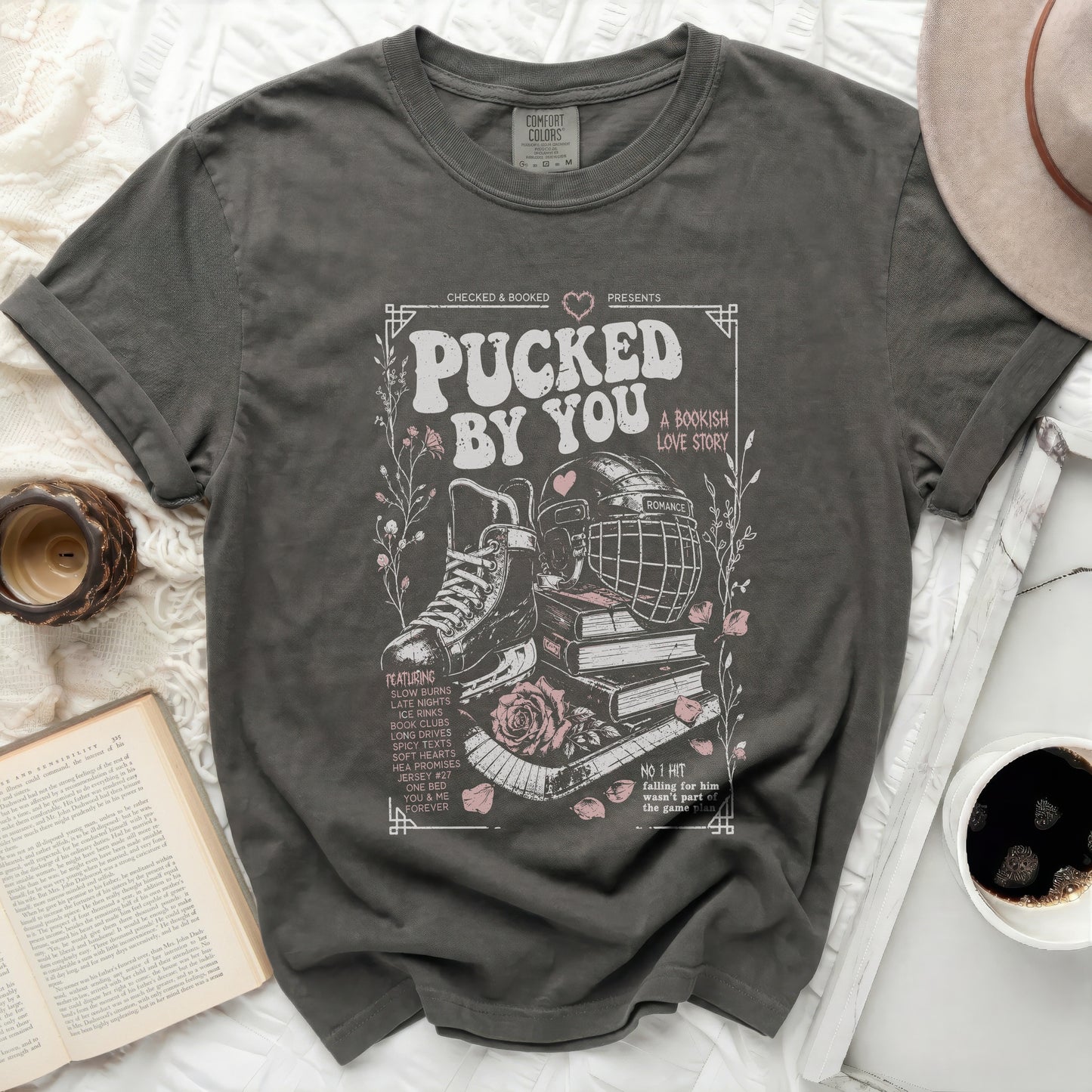 Dark grey t-shirt with "Pucked By You" hockey and book theme graphic.