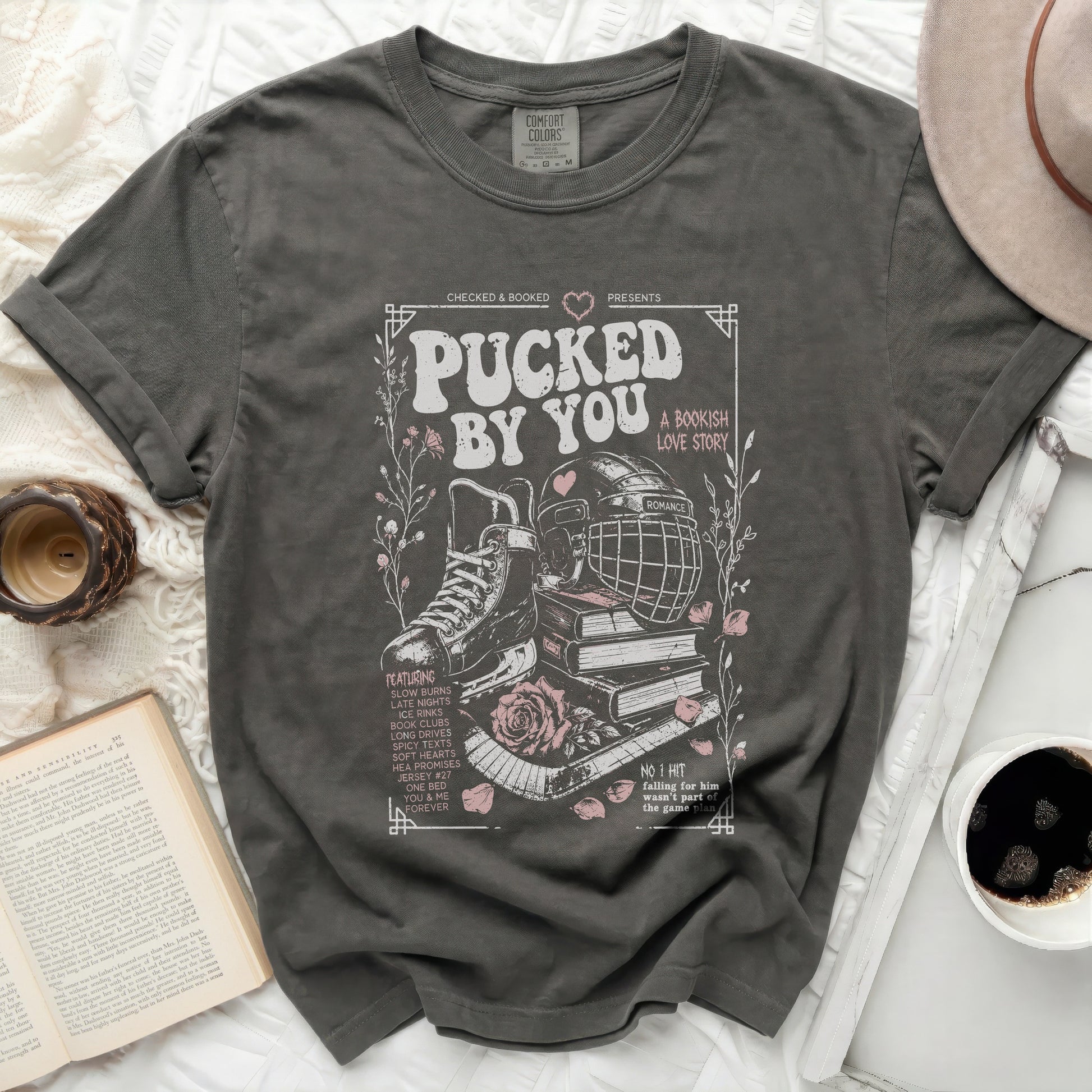 Dark grey t-shirt with "Pucked By You" hockey and book theme graphic.