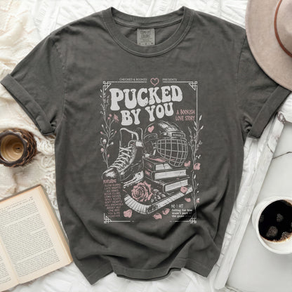 Dark grey t-shirt with "Pucked By You" hockey and book theme graphic.