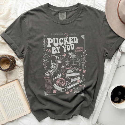 Dark grey t-shirt with "Pucked By You" hockey and book theme graphic.