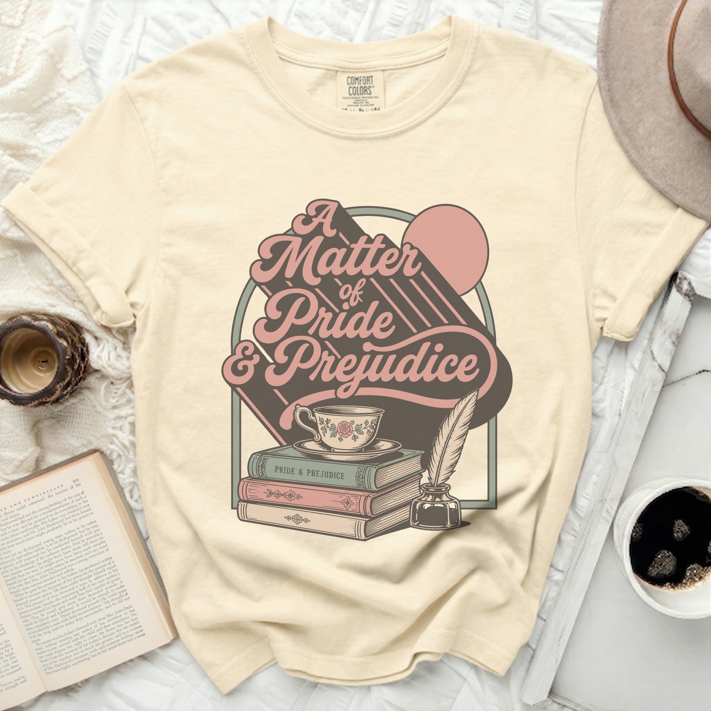 Cream t-shirt with "A Matter of Pride & Prejudice" graphic, teacup, books, and quill.