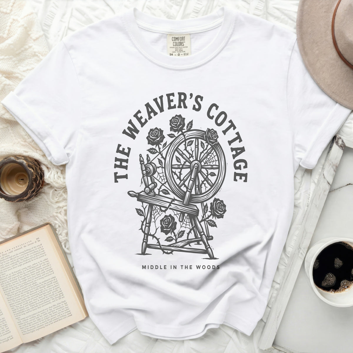 White t-shirt with "The Weaver's Cottage Middle in the Woods" graphic.