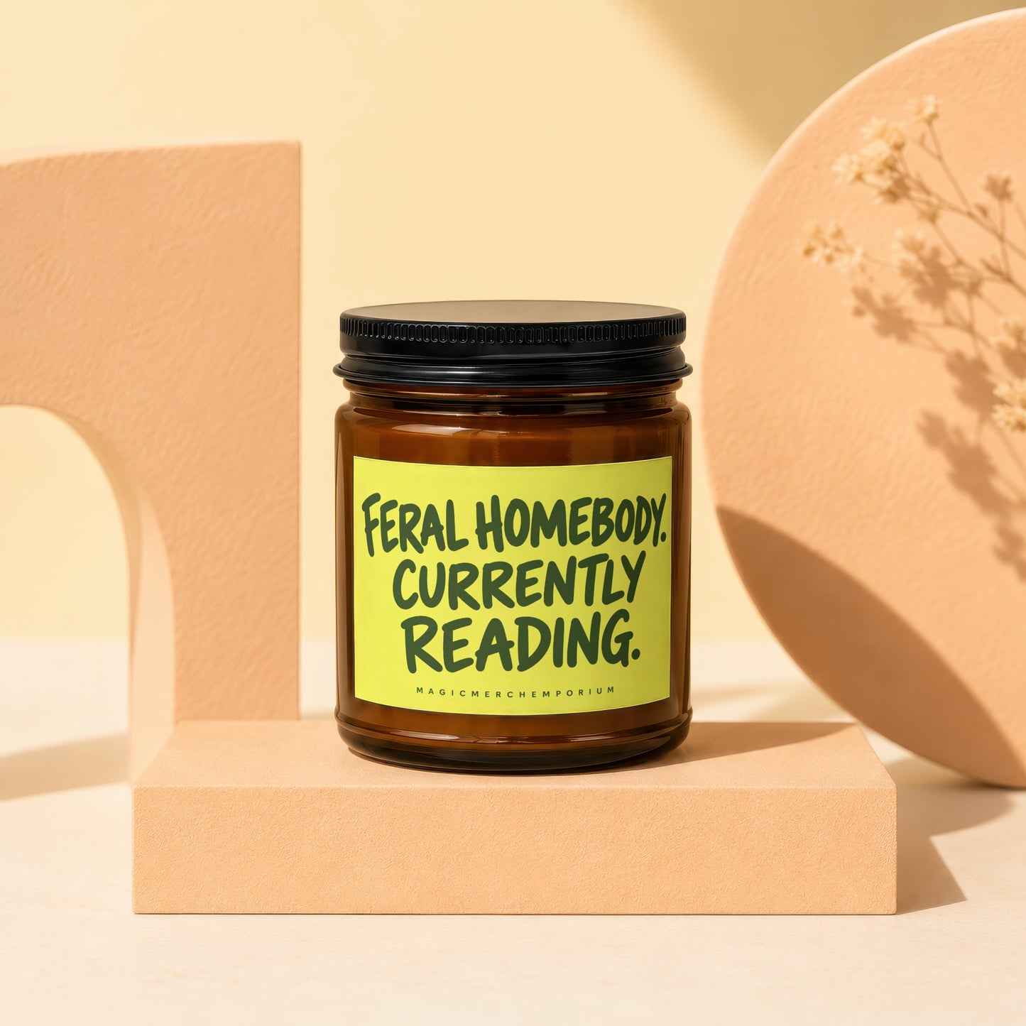 Candle with text "Feral Homebody. Currently Reading." on a bright yellow label.