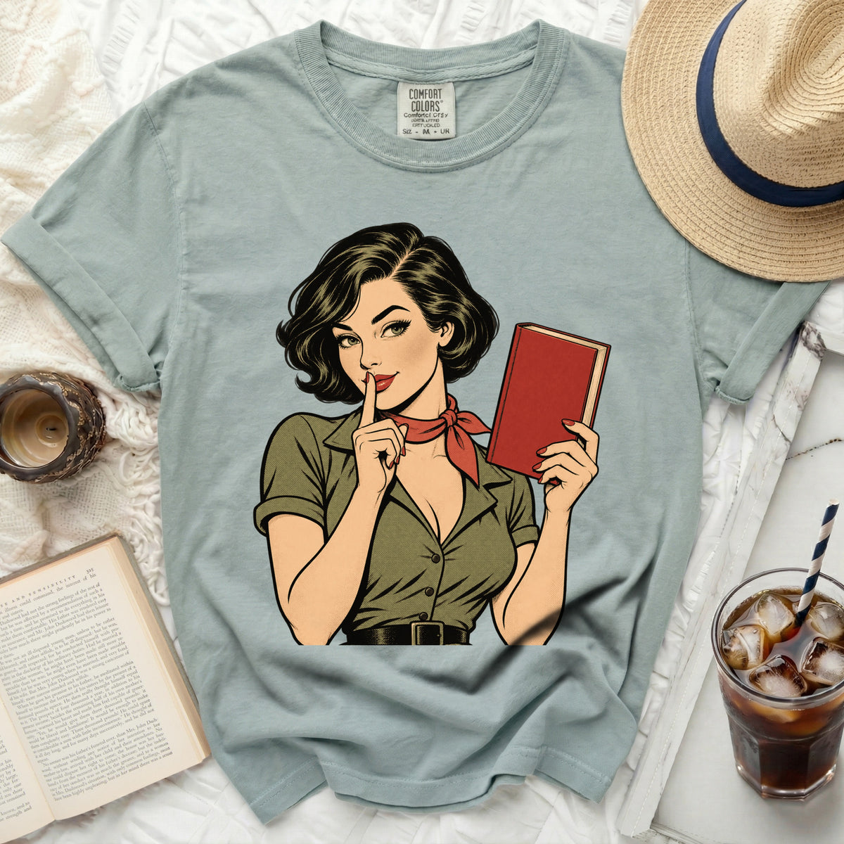 Comic art of a woman with a book and finger to her lips on a t-shirt.