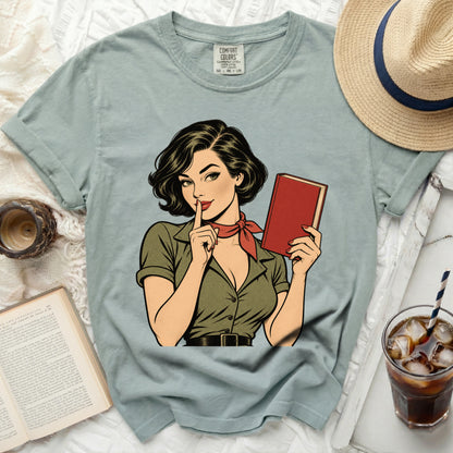 Comic art of a woman with a book and finger to her lips on a t-shirt.