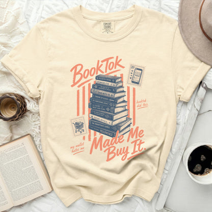 BookTok stack of books graphic on a cream t-shirt, "my wallet hates me" and "Made Me Buy It."