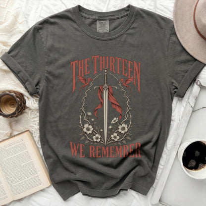 Dark grey t-shirt with "The Thirteen We Remember" text and sword graphic.