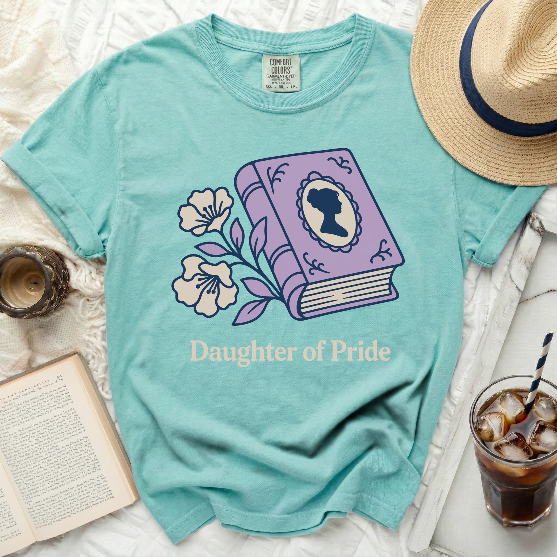 Teal t-shirt with book, flowers, and "Daughter of Pride" text.