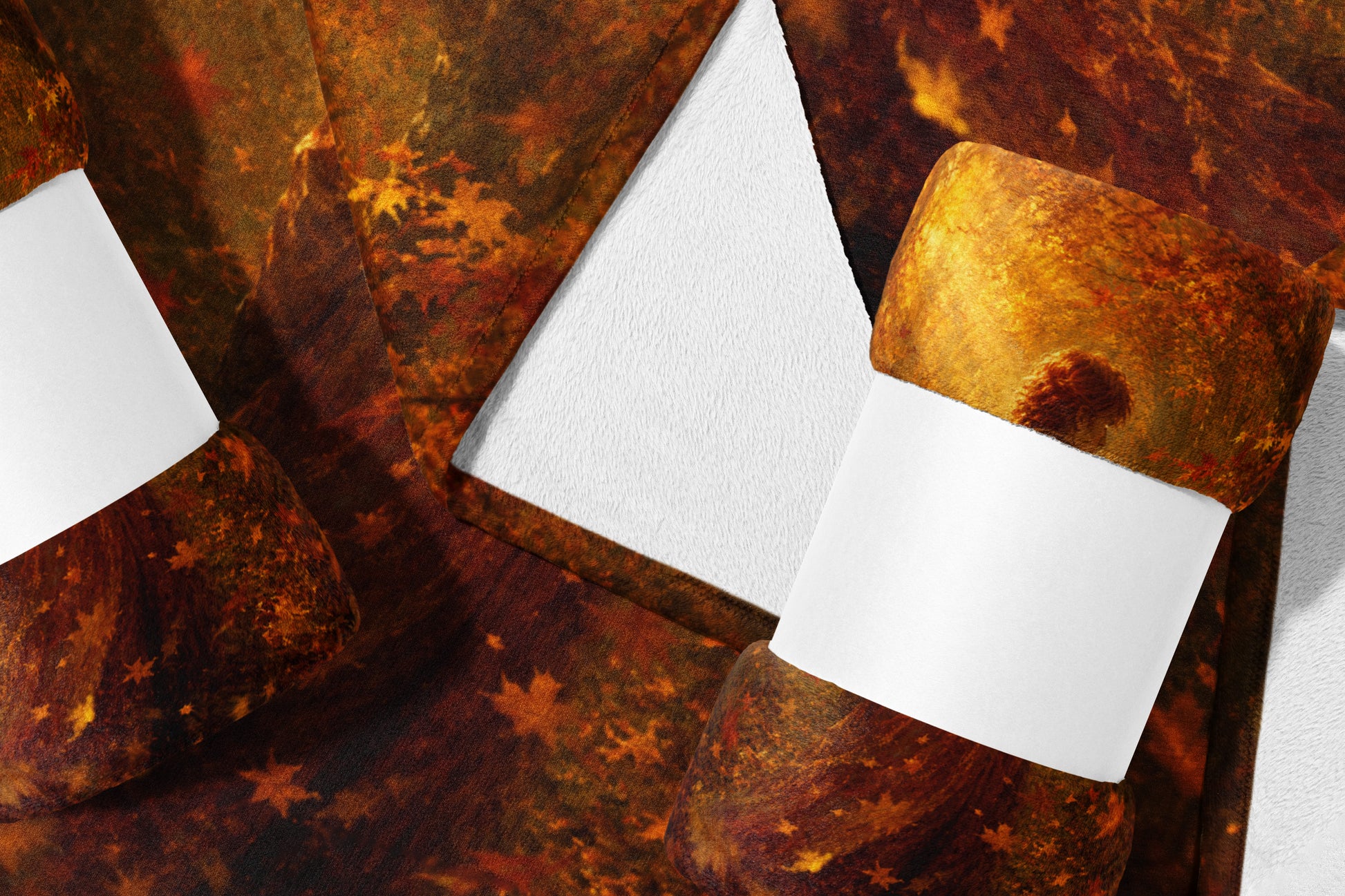Rolled blankets with fall leaf pattern on textured white surface.