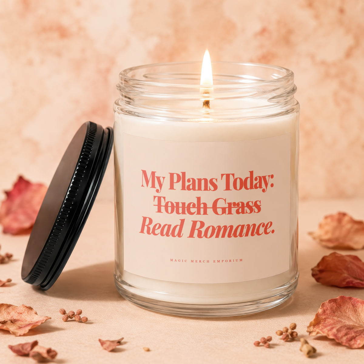Glass candle with lit wick, label reads "My Plans Today: Touch Grass Read Romance."