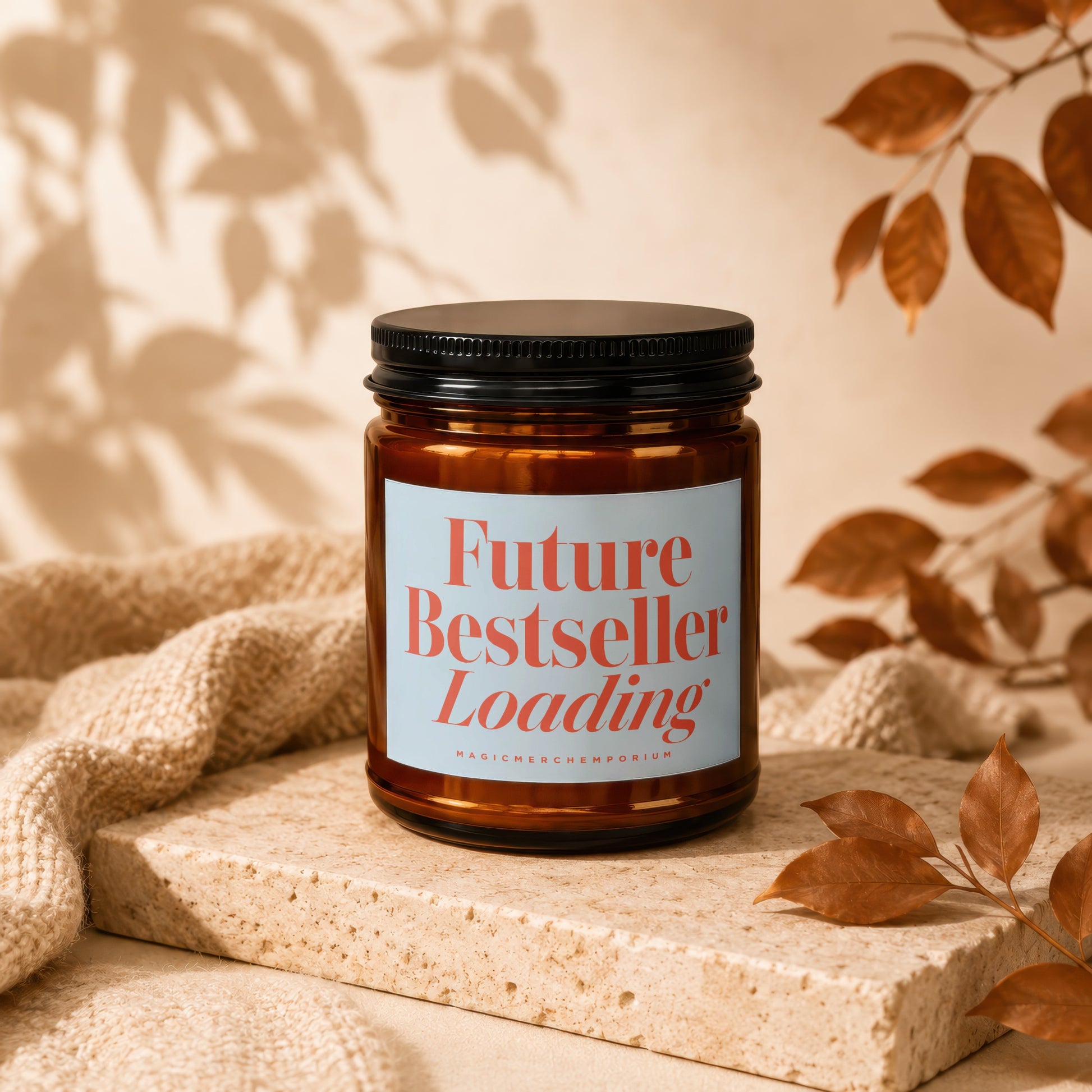 Amber jar candle with black lid reading "Future Bestseller Loading" on light blue label.